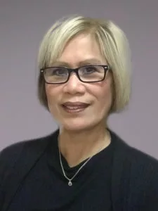 A woman with short light hair and wearing glasses.